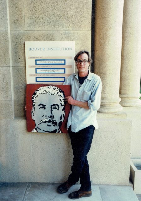 Stencil artist Scott Williams poses with a painting of Russian leader Joseph Stalin outside of the Hoover Institute at Stanford University in the 90's. Photo courtesy of Carla Leshne.