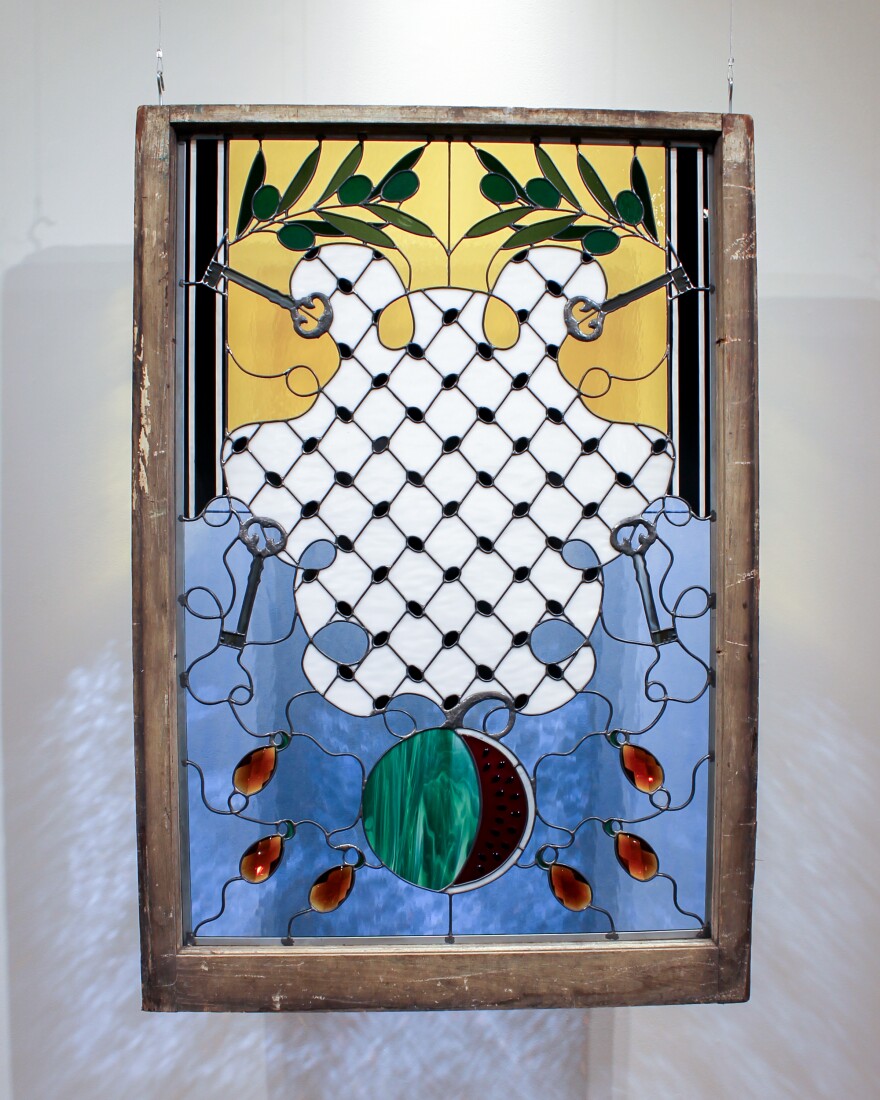 A stained glass work with a watermelon and olive branches
