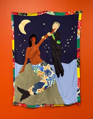 Textile artwork showing Black mermaid holding white man by the neck