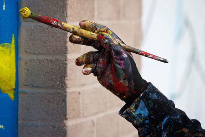 Nico Cathcart of Toronto paints a mural on the side of the ZStone Creations building at 711 South Main Street during Mural Mania on Friday, July 5, 2024, in South Bend. This year marks South Bend's third Mural Mania where artists from around the world paint murals across the city at the same time.