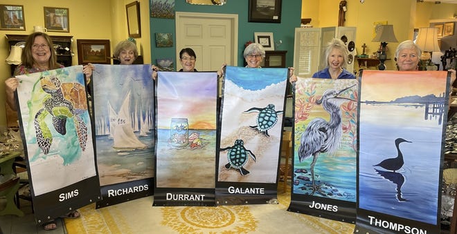 Artists from around the area have their photo taken with their banners before they were posted along Main Street in Destin.