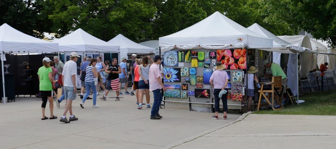 People inspect paintings during the John Michael Kohler Arts Center’s Midsummer Festival of the Arts, Saturday, July 20, 2024, in Sheboygan, Wis.