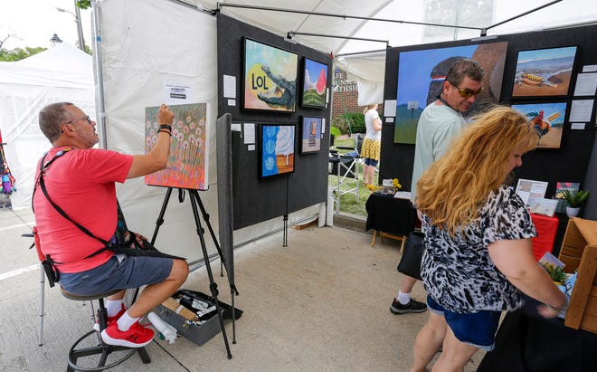 While Sheboygan’s Jason Kotecki creates more art, people check over his offerings at the John Michael Kohler Arts Center’s Midsummer Festival of the Arts, Saturday, July 20, 2024, in Sheboygan, Wis.