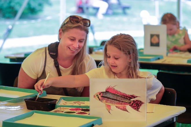 Vivian Hagerman, 8, right, cleans her brush while her mom Ashley observes at the children’s art tent at the John Michael Kohler Arts Center’s Midsummer Festival of the Arts, Saturday, July 20, 2024, in Sheboygan, Wis.