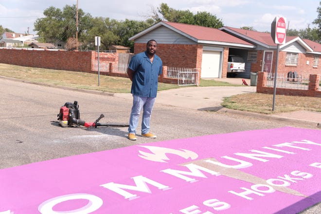 Deandre Jones stands with his mural Tuesday at Bones Hooks Park in Amarillo.