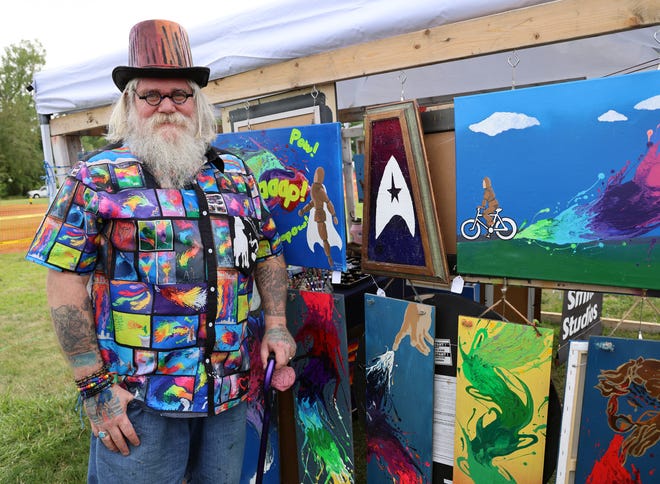 Arthur Smith of Des Moines stands by his work at the Waukee Arts Festival on Friday, July 19. The two-day event at Centennial Park featured local artists and music.