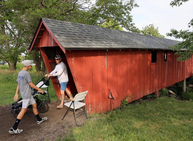 People come and go through the covered bridge during the Waukee Arts Festival on Saturday, July 20. The two-day event at Centennial Park featured local artists and music.