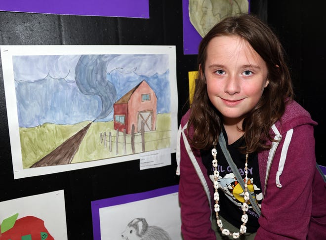 Cora Agness, fourth grade, stands by her watercolor painting on display during the Waukee Arts Festival on Saturday, July 20. The two-day festival at Centennial Park featured local artists and live music.