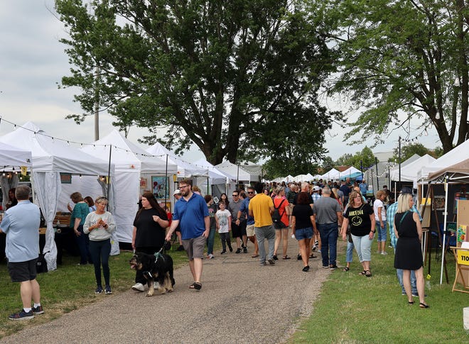 Art shoppers enjoy the Waukee Arts Festival on Friday, July 19. The two-day festival at Centennial Park featured local artists and live music.