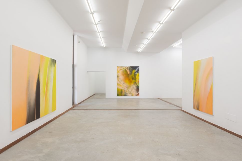 Photo of a white cube room with yellow paintings