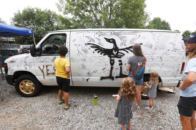 Locals contribute to a bird van with local artist Peter Loose at FoxSaid Festival at the Cotton Press in Athens, Ga., on Saturday, July 27, 2024. The art and music festival featured interactive art with a number of local artists and raised money for art education in local schools.