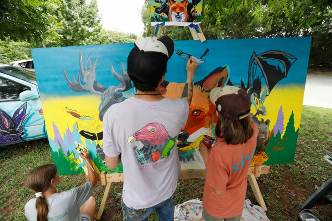 Local kids help paint a mural with local artist Will Eskridge at FoxSaid Festival at the Cotton Press in Athens, Ga., on Saturday, July 27, 2024. The mural is part of Athens Downtown Development Art Decko project. It will be placed inside the downtown College Avenue parking deck stairwell.