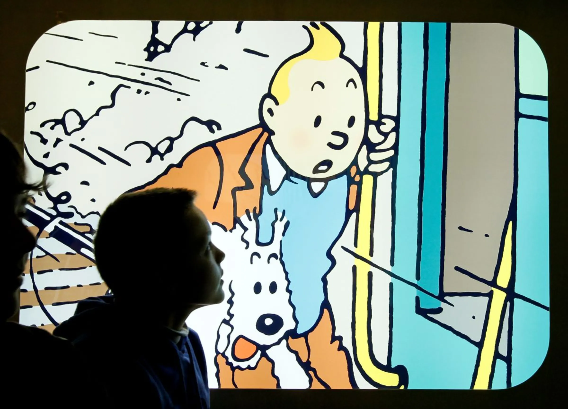 A student looks at a lightbox depicting the comic strip character Tintin by Brussels-born author Georges Remi, better known as Herge, displayed in a shop at the Herge Museum in Louvain-La-Neuve December 1, 2011. REUTERS/Yves Herman/Herge-Moulinsart
