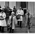 A black and white photo of a group of people walking down steps.