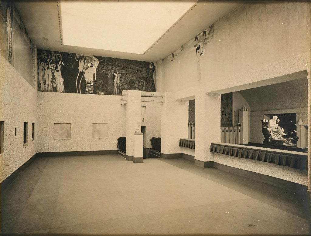 Black and white photograph of a Vienna Secessionists exhibition with a large mural by Gustav Klimt