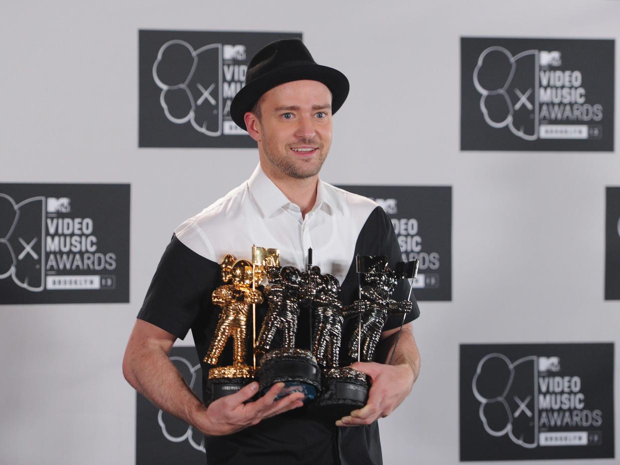 Justin Timberlake holding his awards at the 2013 VMAs.