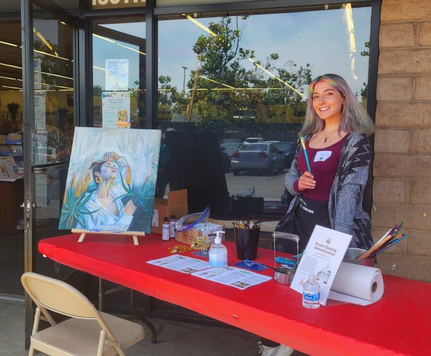 Painter and Palace Art supervisor Leelah Maurer was greeting patrons into the store Saturday for the 75th anniversary celebration and showing off her own work, alongside advocating for more sustainable ways to clean paint brushes. (Aric Sleeper/Santa Cruz Sentinel)