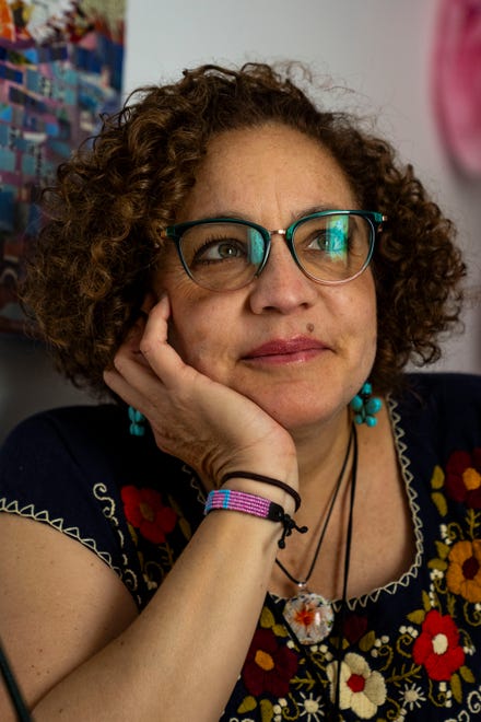 Artist Mary Mindiola looks out the window Friday, July 5, 2024, at her studio in Indianapolis. Mindiola creates detailed work made from cut magazine paper after a trip to the Cayman Islands, where she found a large amount of single-use plastic along the beach shoreline.