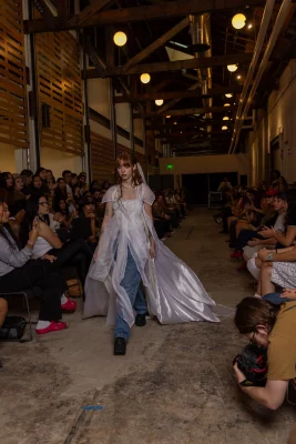 A model walks in a shiny white cape.