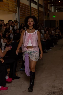 A model wears an outfit of pink and purple draped mesh.