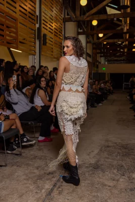 A model's white and cream outfit displays many textures.