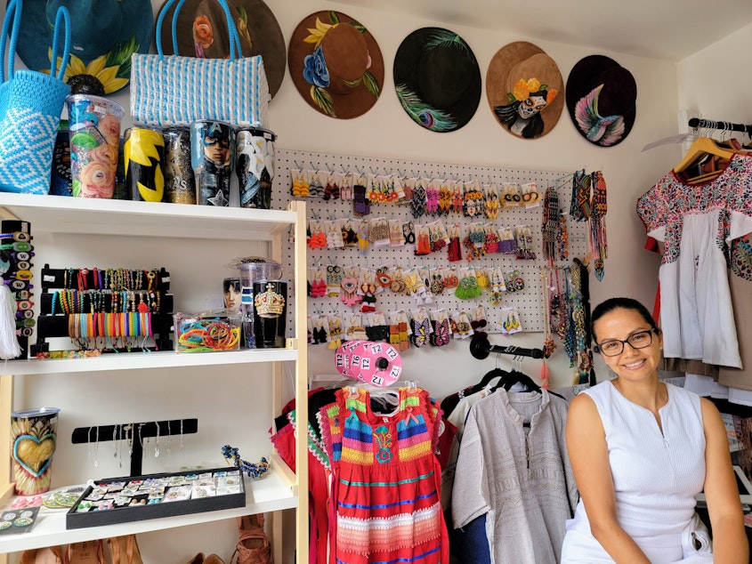 caption: Flor Moreno inside her tiny pop-up shop at Pier 55 in Seattle on Tuesday, Aug. 13, 2024.